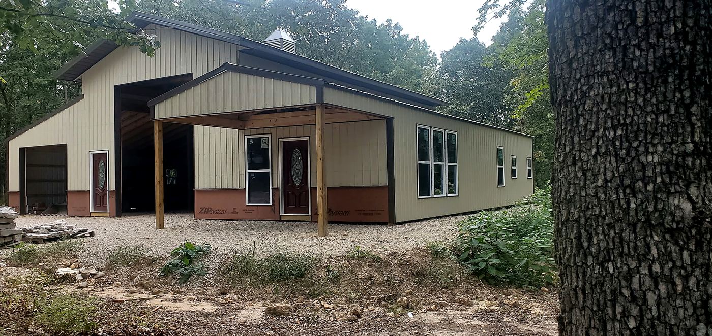Barndominium exterior with front entrance and attached garage bay